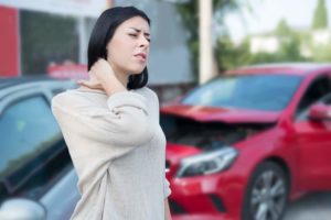 Injured woman feeling neck pain after car crash